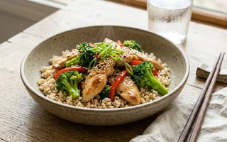 Bol de arroz integral con salteado de pollo, brócoli y pimiento rojo con sésamo